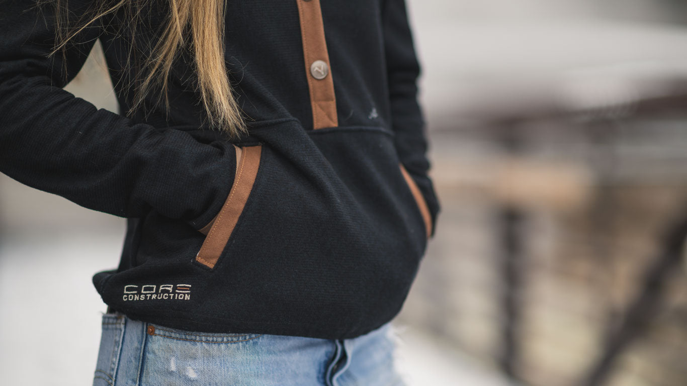 Close up of woman wearing Core Construction chalet pullover with hands in pocket